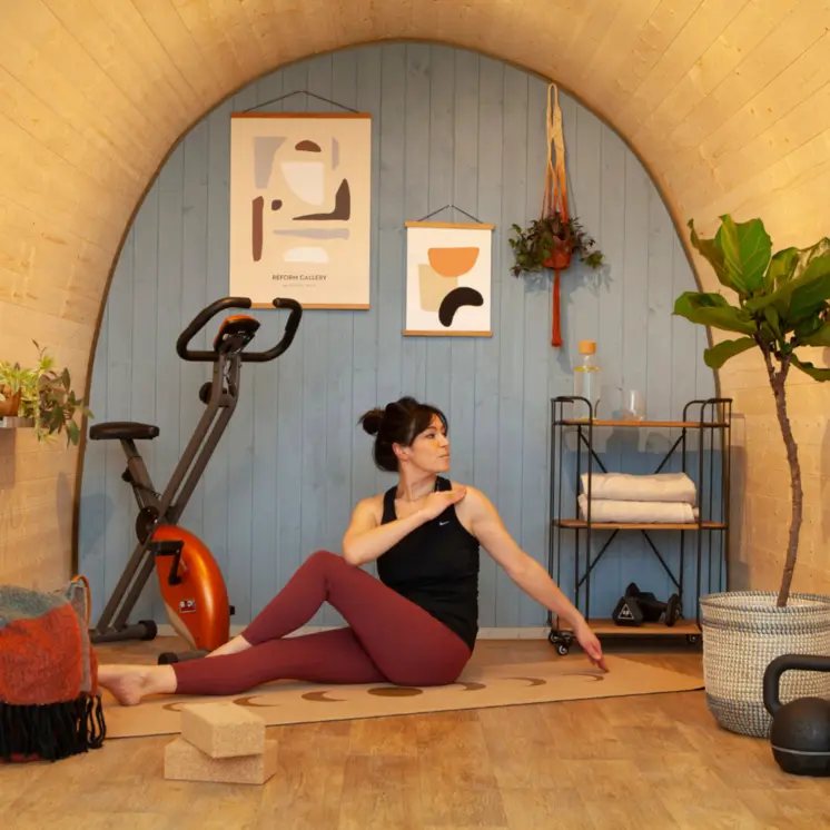 A spacious and inviting Hully Pod transformed into a garden room gym, set against a tranquil UK garden backdrop.